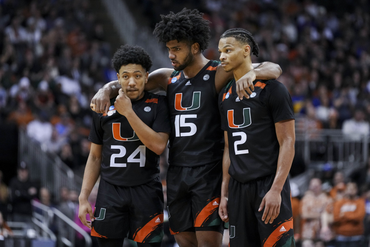 Nijel Pack (24), forward Norchad Omier (15), and guard Isaiah Wong (2) stand on the court together with their arms over each others shoulders